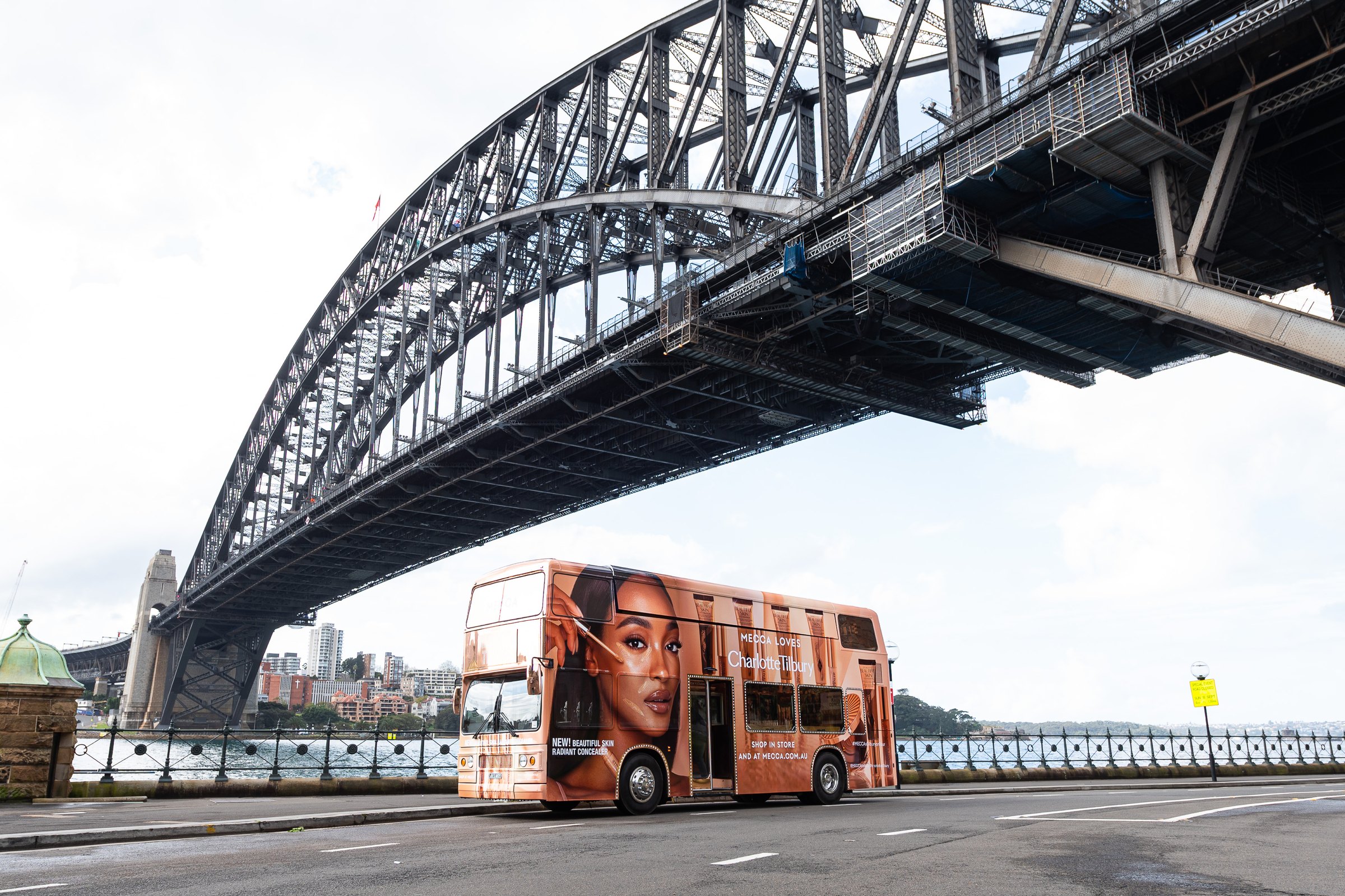 MECCA Beautiful Skin double-decker bus beneath Sydney Harbour Bridge