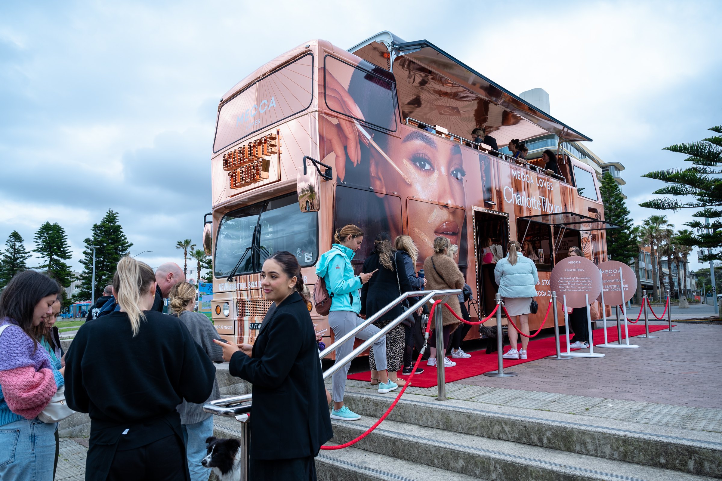 Visitors gathering around the fully branded MECCA activation bus
